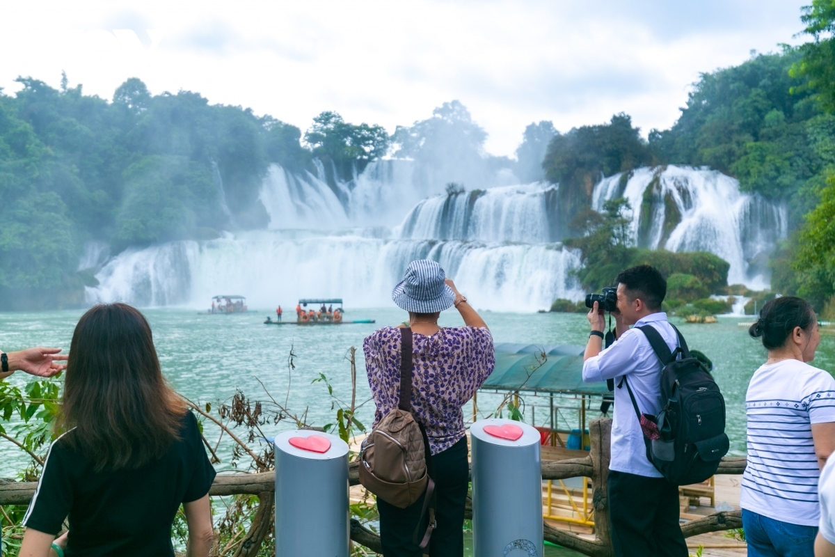 vietnamese and chinese tourists admire ban gioc - detian waterfalls picture 5