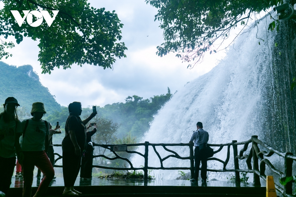 vietnamese and chinese tourists admire ban gioc - detian waterfalls picture 7